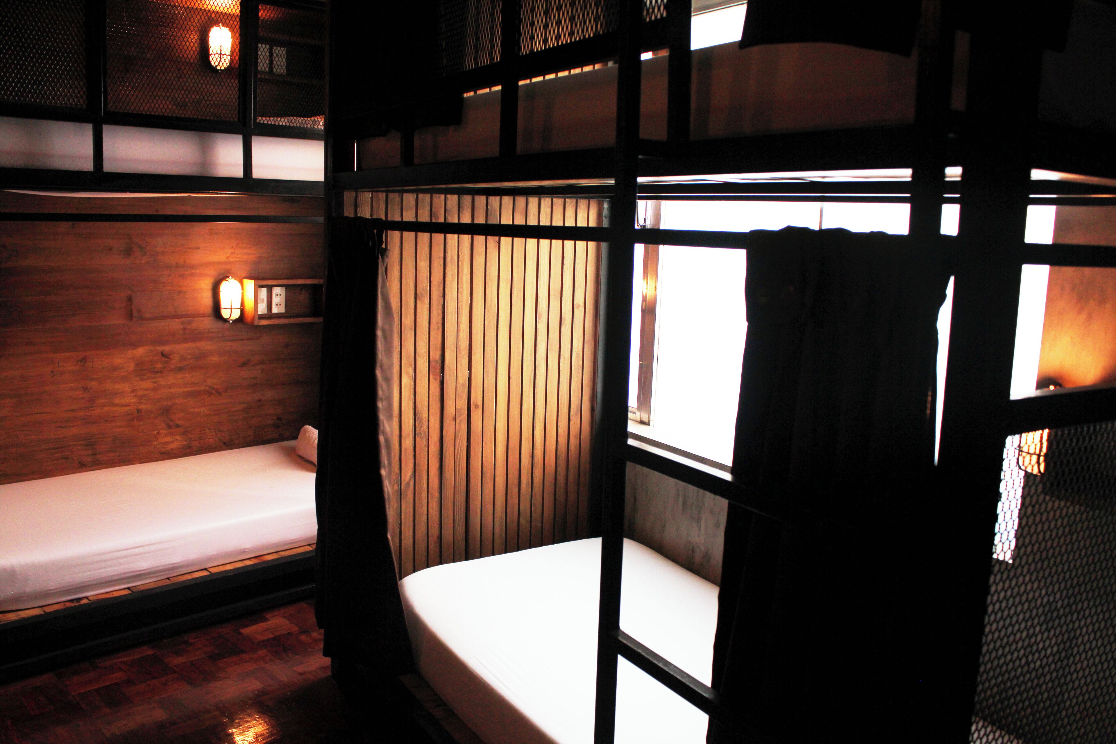 A bunk bed room with wooden walls and a window.
