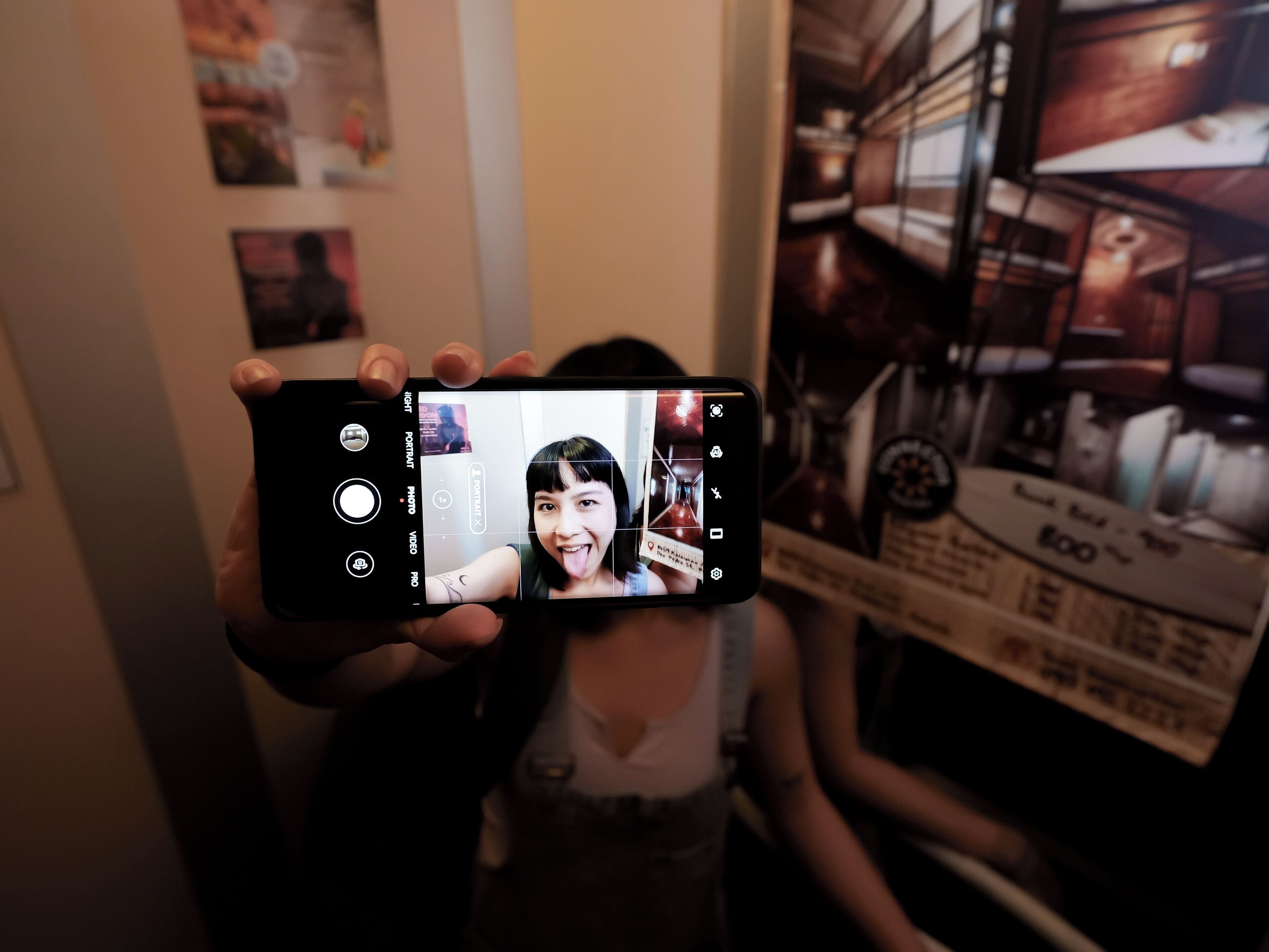 Un téléphone intelligent affichant un autoportrait d’une personne dans une pièce.
