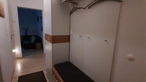 Ein gemütliches Schlafzimmer mit eingebautem Sitzbank, Kleiderschrank und Ablagefläche.