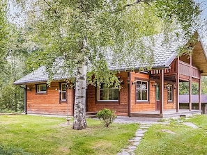 A wooden cabin with a porch, surrounded by trees and a stone pathway. - Haaparanta by Interhome (Ruovesi)
