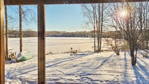 A snowy landscape with a frozen lake, bare trees, and a wooden structure. - Haaparanta by Interhome (Ruovesi)