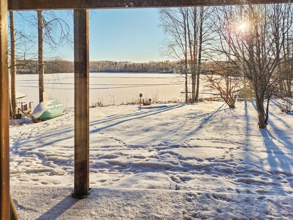A snowy landscape with a frozen lake, bare trees, and a wooden structure. - Haaparanta by Interhome (Ruovesi)