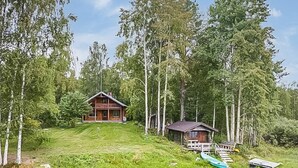 A cabin surrounded by tall trees, with a small dock and a canoe nearby. - Haaparanta by Interhome (Ruovesi)