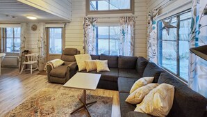 A cozy living room with a sectional sofa, a small table, and a window with curtains. - Haaparanta by Interhome (Ruovesi)