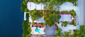 An aerial view of a resort with multiple villas, a swimming pool, and lush greenery. - Heated Pool, Dock, Kayaks, on Lagoon, Turtle Beach 1-mile & Crescent Beach 2-miles, 3-units (Siesta Key)
