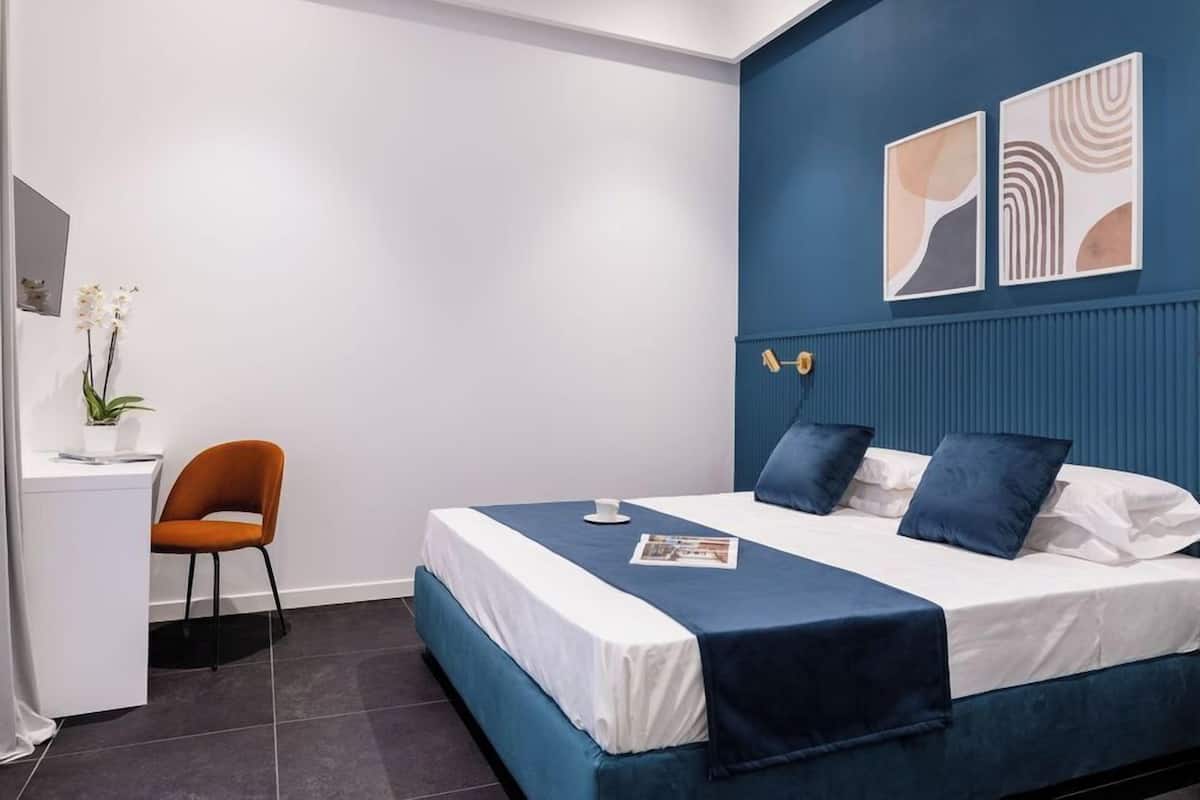 Un dormitorio moderno con cama, escritorio y silla.