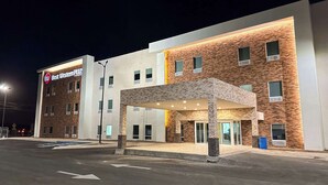 Un hotel dal design moderno, con facciata in mattoni e area d'ingresso coperta.