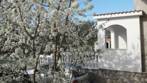 A white building with a stone base and a small arched window. - Apartment Antonio (Bilice)