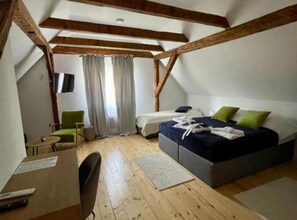 Ein Schlafzimmer mit Bett, Schreibtisch, Stuhl und einem Fenster mit Vorhängen.