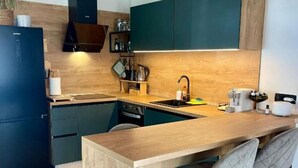 A modern kitchen with a wooden island, bar stools, and a built-in oven.