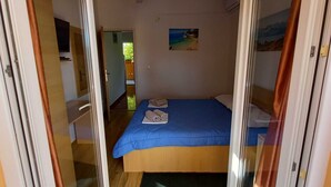 Ein Schlafzimmer mit einem Bett, einem Deckenventilator und einem Bild an der Wand.