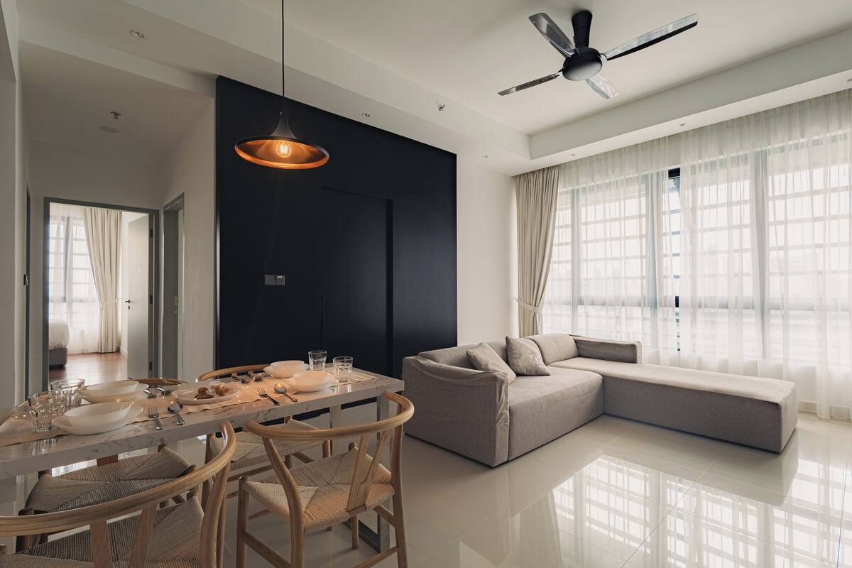 Un salon moderne comprenant un coin repas, un canapé et un ventilateur de plafond.