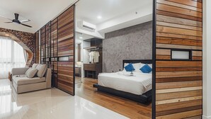 Une chambre à coucher moderne avec un mur recouvert de panneaux en bois, un lit avec des coussins bleus, un canapé et un dressing.