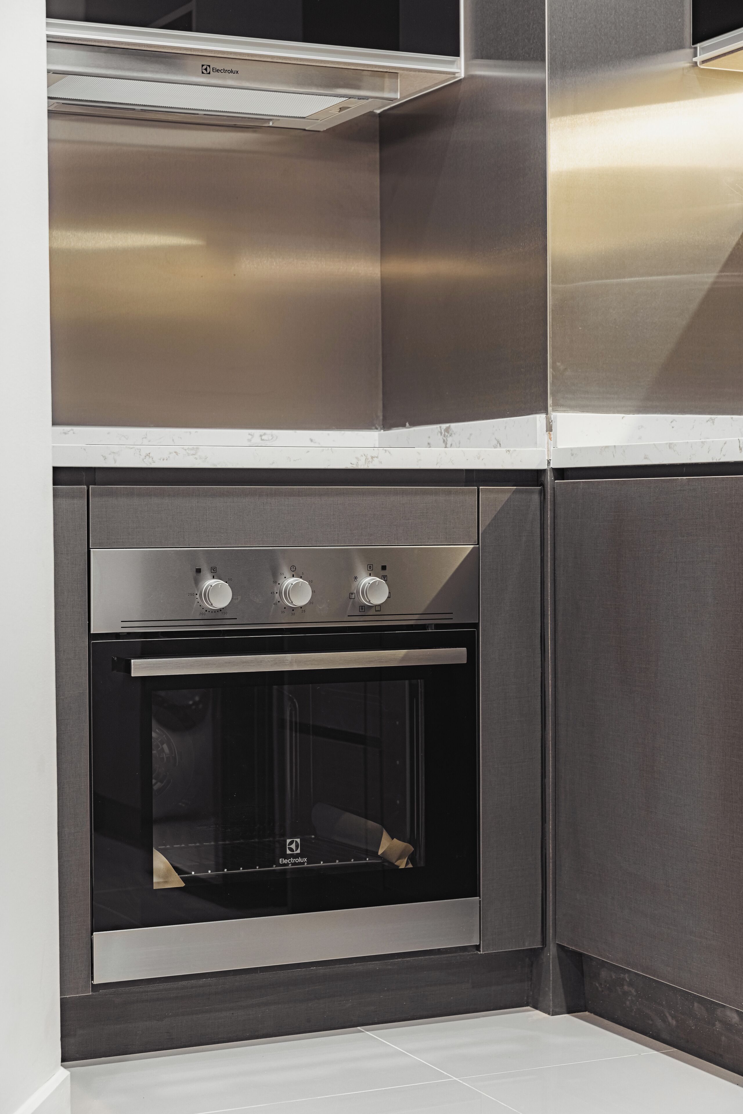 A modern kitchen with stainless steel appliances, including an oven and a range hood.