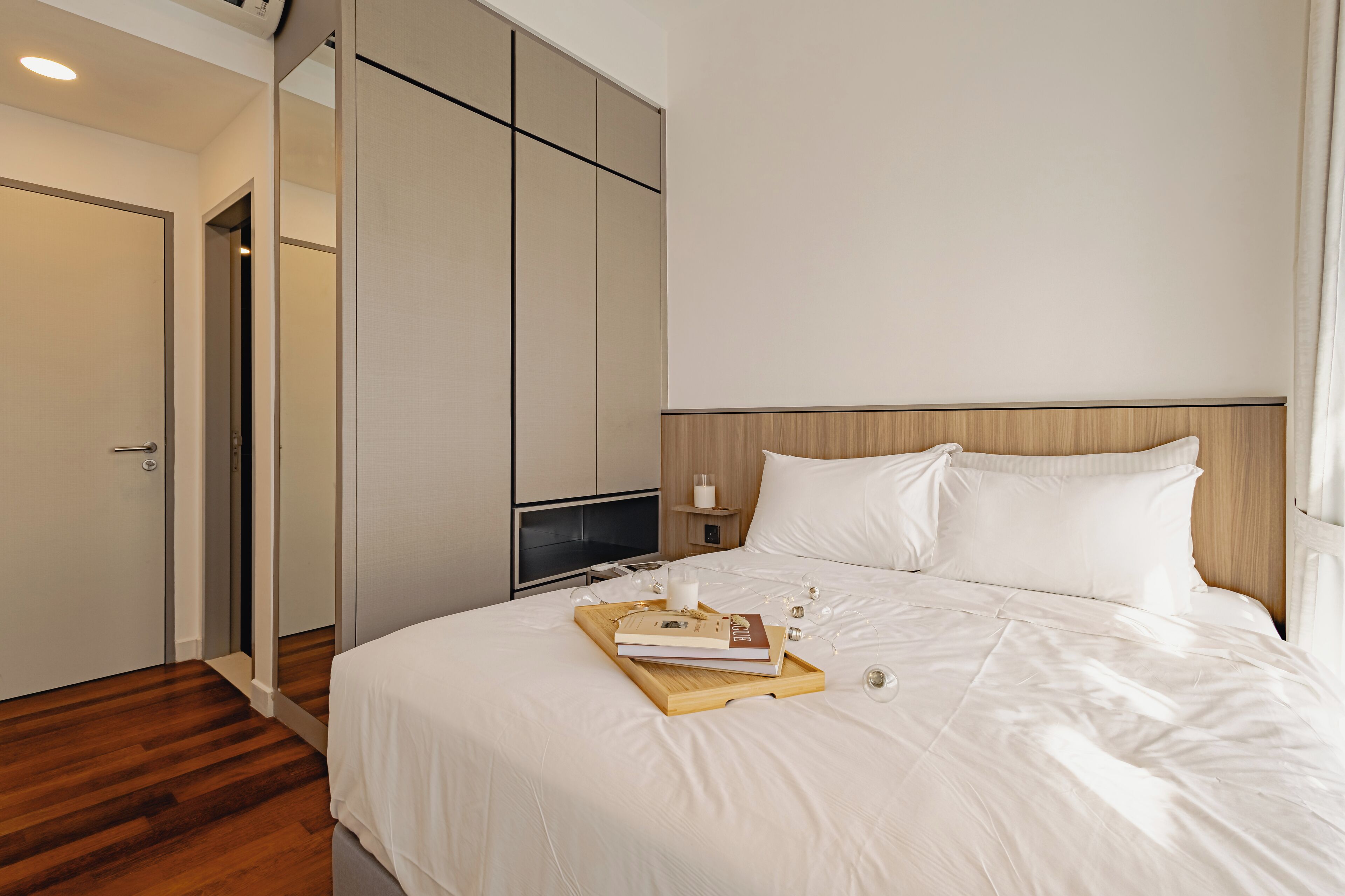 Quarto de hotel com cama, mesa de cabeceira e guarda-roupa.
