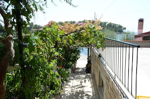 A pathway leading to a beach, flanked by a metal railing and a stone wall. - Apartments Prižba Bay (Blato)