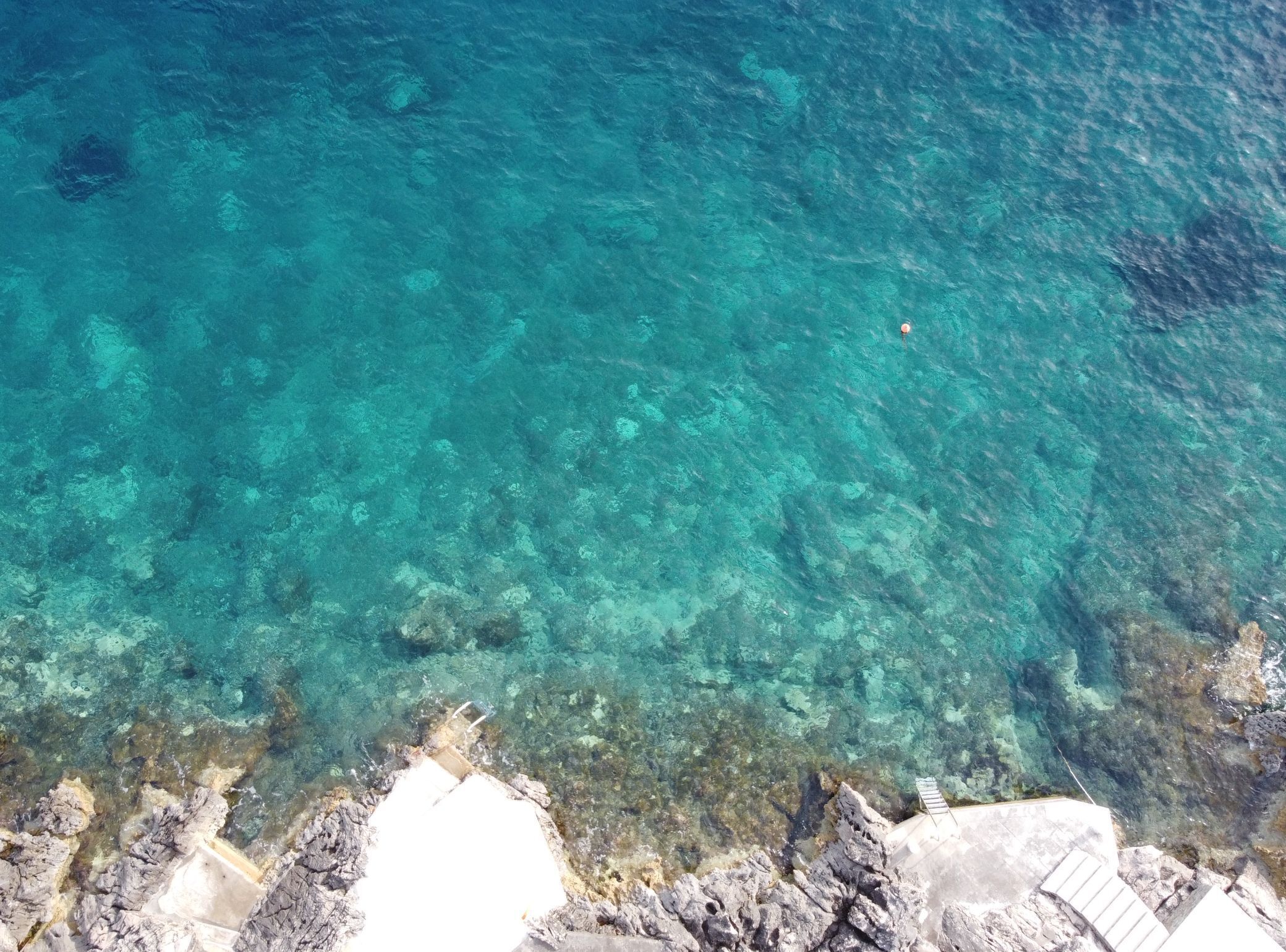 A clear view of a rocky shoreline with shallow water.