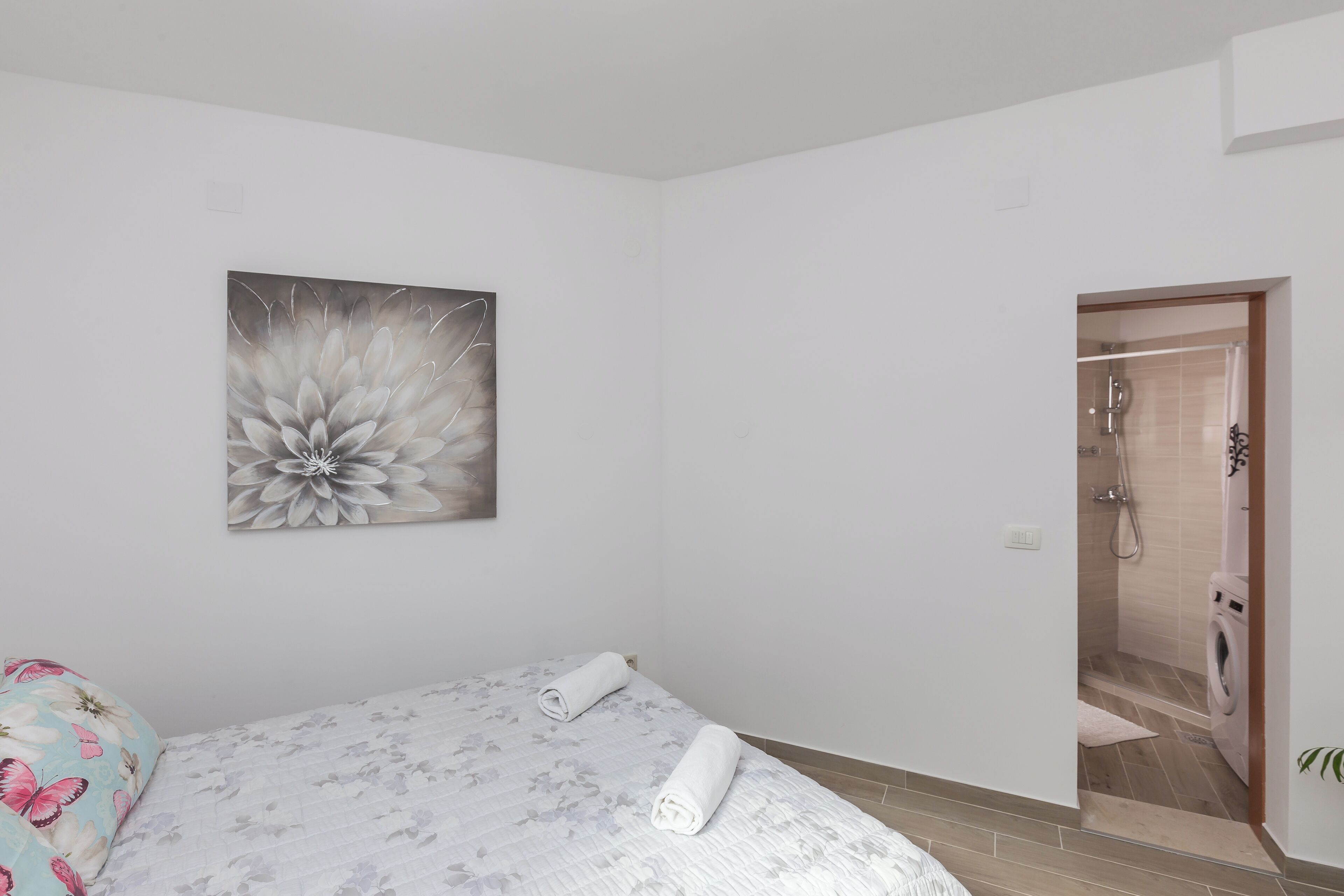 Een slaapkamer met een bed, een douche en een toilet.