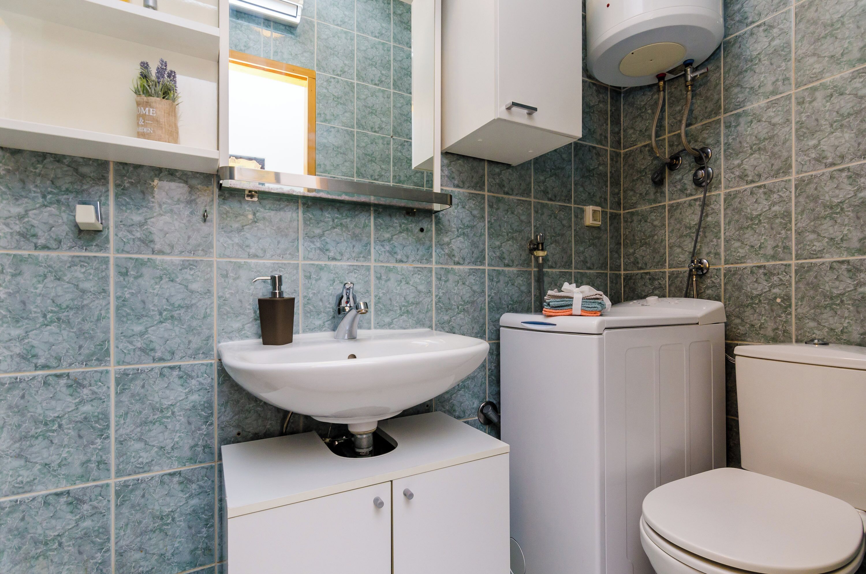 A bathroom with a white sink, a toilet, and a shower area.