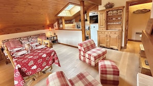 A cozy dining area with a red tablecloth, wooden chairs, and a view of the kitchen. - Charming 2-BR + Cabin, Sleeps 6, Close to Jaillet Gondola and Sports Palace - Megève (Megève)