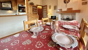 A dining area with a red tablecloth, wooden chairs, and a fireplace. - Charming 2-BR + Cabin, Sleeps 6, Close to Jaillet Gondola and Sports Palace - Megève (Megève)