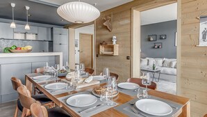 A modern dining area with a wooden table set for six, surrounded by leather chairs. - Premium 4* Apartment 8 Pers, Lake View, Wifi, Tignes (Tignes)