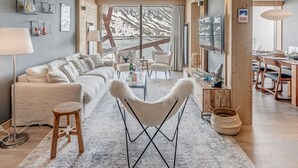 A modern living room with a sofa, armchairs, a coffee table, and a dining area with a table and chairs. - Premium 4* Apartment 8 Pers, Lake View, Wifi, Tignes (Tignes)