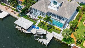 A waterfront property with a large house, a swimming pool, and a dock. - Waterfront 4BR Marco Island home with heated pool, WiFi & kitchen. (Marco Island)