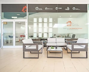 A modern office space with a reception area featuring a sofa set and a coffee table.