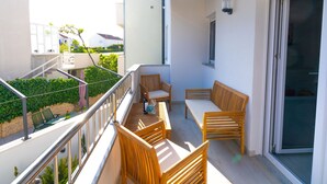 A balcony with wooden furniture, a table, and chairs. - Lucius 1 by Interhome (Podstrana)