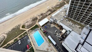 An aerial view of a coastal hotel with a beach, parking area, and a swimming pool. - Oceanfront 3BR , Pool, 2 Balconies, Views by Karsons Keys (Ocean City)