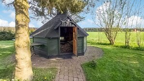 Eine kleine Holzhütte mit geneigtem Dach, einer Tür und einem Schornstein.