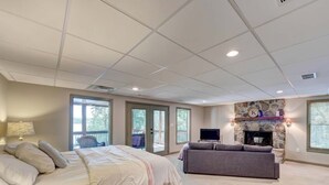 A bedroom with a bed, a sofa, a TV, and a fireplace. - Cozy 3BR Cabin with Lake View in Dawsonville (Dawsonville)