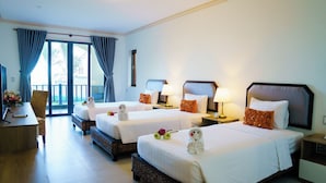A hotel room with three beds, a desk, and a TV. - Blooming Lotus Resort (Tien Thanh)
