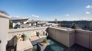 A rooftop terrace with a sofa set and a coffee table, overlooking a cityscape. - Newly Modern 2B2B Home near Seatac - Golf course (Seattle)