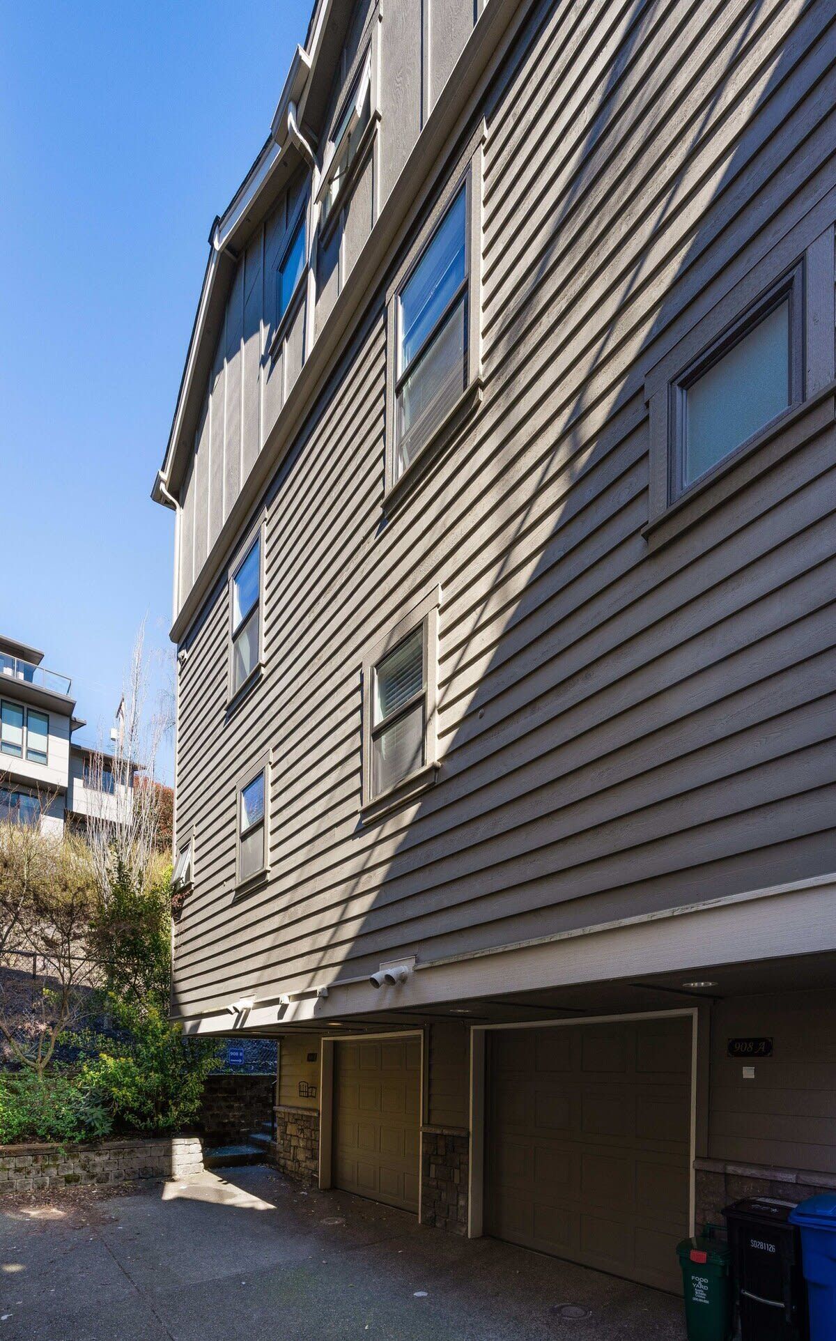 A multi-story building with a garage and a small driveway.