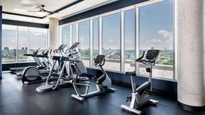 A gym with cardio machines and large windows offering a city view. - 2BR Oasis w/ Gym & Terrace, Near Hintonburg! (Ottawa)