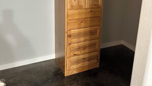 Une pièce d’angle avec un meuble en bois et une étagère blanche.