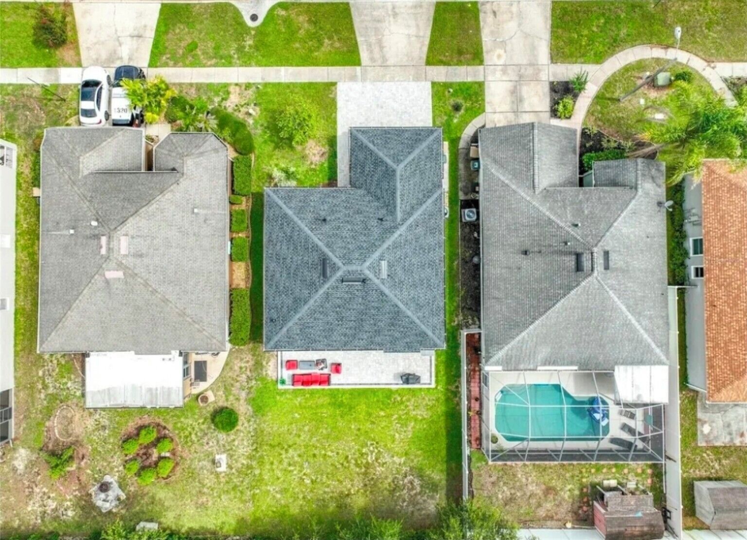 A residential area with multiple houses, a swimming pool, and a driveway.