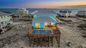 Une propriété située en bord de mer, comprenant plusieurs maisons, une terrasse en bois et une piscine.