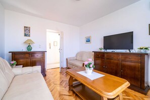 Appartement (Three-Bedroom Apartment with Balcony ) | Woonkamer | Een 32-inch flatscreentelevisie met satellietzenders