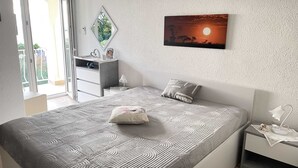 A bedroom with a bed, a nightstand, a dresser, and a wall-mounted picture. - Apartments Belenum (Zupa dubrovacka)