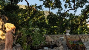 A garden with a statue, a stone wall, and a wooden planter with flowers. - Apartments Belenum (Zupa dubrovacka)