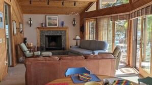 Una sala de estar acogedora con chimenea, asientos cómodos y un comedor con individuales de colores.