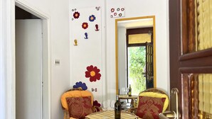 A dining area with wicker chairs and a round table, a mirror, and wall decorations. - Apartments More & Ja (Ston)