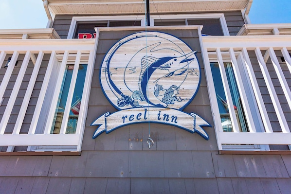 A building with a sign that reads 'reel inn' and a logo featuring a fish.