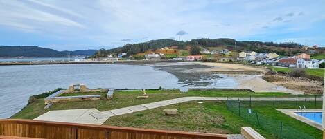 Una propiedad frente al mar con una terraza de madera y piscina.
