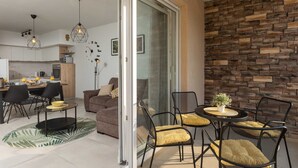 A modern living space with a dining area, a sofa, and a seating arrangement with chairs and a table. - Apartment Why Not (Dubrovnik)