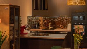 Una cocina moderna con una isla central, electrodomésticos de acero inoxidable y un original salpicadero hexagonal.