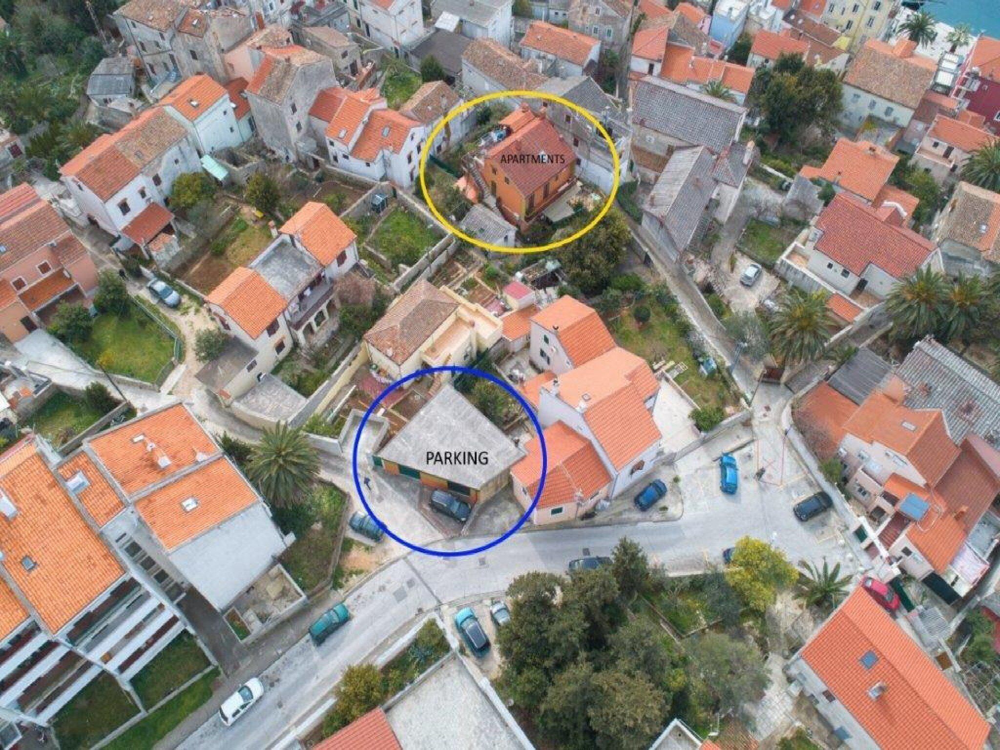 Luchtbeeld van een woongebied met appartementen en parkeerplaatsen.